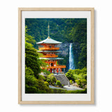 Framed art print featuring a Japanese pagoda and waterfall in a lush green forest, displayed in a light wood frame with a white mat.