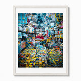 A framed art print featuring a colorful photograph of Akihabara man in Japan in his electronics store, displayed in a white wood frame with a white mat against a plain white background.