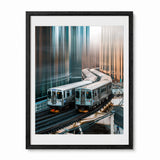 A framed art print depicting two silver subway trains in Chicago on elevated tracks between tall, reflective skyscrapers, presented in a black frame with a white mat against a light gray background.