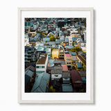 A framed art print featuring an aerial photograph of Face House against a dense Kyoto neighborhood with varied rooftops, presented in a white frame