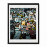 A framed art print featuring an aerial photograph of Face House against a dense Kyoto neighborhood with varied rooftops, presented in a black frame.