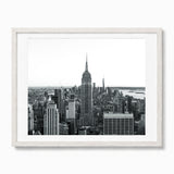 A framed landscape black and white photography print of the empire state building and new york cityscape, set in a white frame