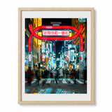 Framed wall art featuring people walking in Shinjuku Tokyo at night and neon signs in the background, shown in a wood frame