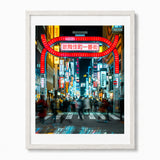 Framed wall art featuring people walking in Shinjuku Tokyo at night and neon signs in the background, shown in a white frame.