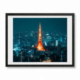 Framed photographic art print of the Tokyo Tower at night, surrounded by a white mat and a black wood frame, shown against a plain white background.