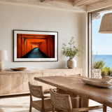 Framed landscape wall art featuring a tunnel of red orange torii gates in Kyoto, Japan - shown in a black frame with white mat hanging on a wall in a dining room