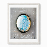 Framed wall art featuring an aerial photograph of The Bean sculpture in Chicao, a circular mirror reflecting the Chicago city skyline over a tiled plaza, presented in a white frame.