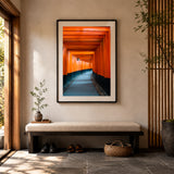A black framed print of Kyoto's Torii Gates, placed on a wall in an entryway
