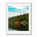 A framed art print featuring a scenic landscape of Mount Fuji reflected in a calm lake, with a bright red torii gate in the foreground and green forest under a blue sky.