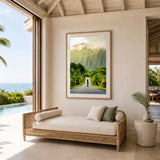 A framed photography print of a woman walking on a road in Hawaii, set in a sunlit home.