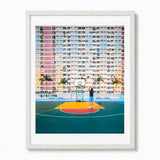 A framed photographic art print depicting a person playing basketball in a hong kong colorful high-rise building, presented in a white frame with a white mat.