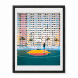A framed photographic art print depicting a person playing basketball in a hong kong colorful high-rise building, presented in a black frame with a white mat.