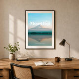 Framed wall art featuring mount fuji reflected over water and decorative text showing the word "Mount Fuji" and the coordinates presented in a black frame and hanging on a wall in a home office.