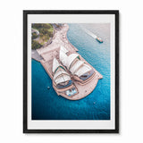A framed aerial photograph of the Sydneys Opera House surrounded by bright blue water, shown in a black frame with a white mat against a light gray background.