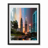 A framed vertical art print of the Petronas Towers in Kuala Lumpur, Malaysia, featuring a vibrant sunset sky with vertical color bands and illuminated skyscrapers, enclosed in a black frame with a white mat.