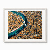 A framed aerial photograph of Venice, showcasing the Grand Canal winding through a dense city with terracotta-colored buildings, presented in a white frame with a white mat against a clean white background.