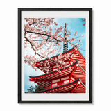 Framed art print featuring a red Japanese pagoda and pink cherry blossoms against a blue sky, presented in a black frame.