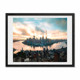 Framed panoramic art print of the Shanghai skyline at sunset, featuring the Huangpu River, modern skyscrapers, and a dramatic cloudy sky, presented in a black frame with a white mat.