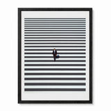 Framed minimalist wall art featuring a small figure in a suit walking across a pedestrian crossing in Shinjuku Japan, shown in a black frame.