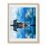 Framed wall art featuring the Singapore city skyline reflection print, Marina Bay Sands and a glowing Ferris wheel, shown in a light wood frame.
