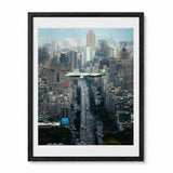 A framed photographic print of a busy city street with an airplane flying over the Taiwan skyline, shown in a black frame with a white mat on a light gray background.