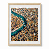 A framed aerial photograph of Venice, showcasing the winding blue Venetian Canal surrounded by dense orange-brown buildings, presented in a light wood frame.